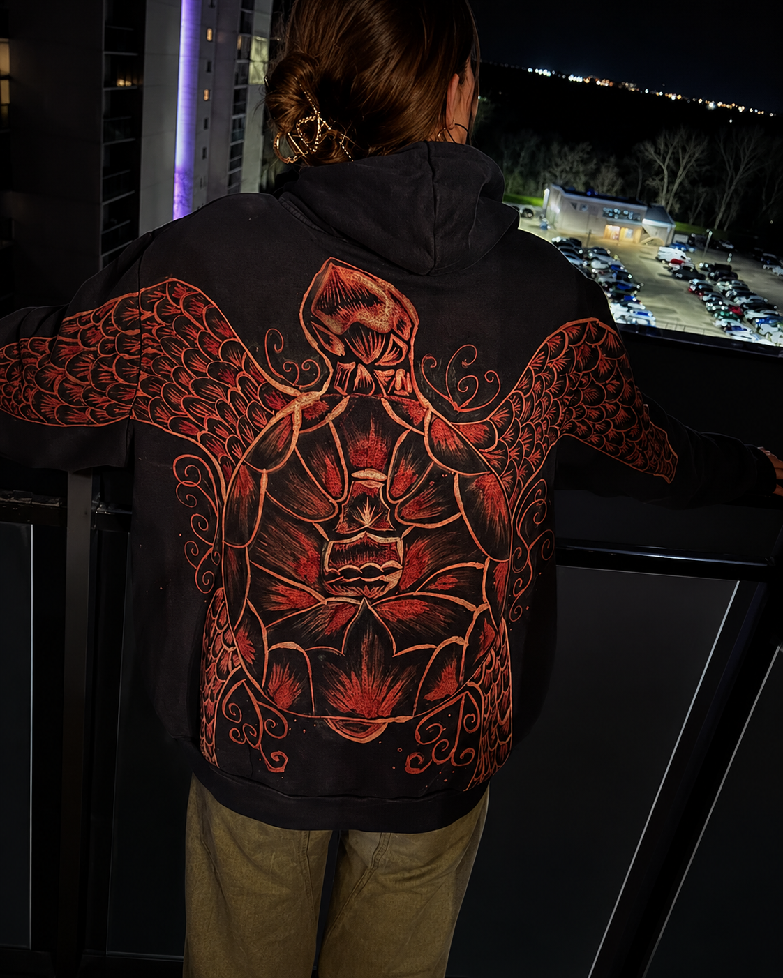 Black Manta bleach art hoodie with red detailed artwork on a balcony